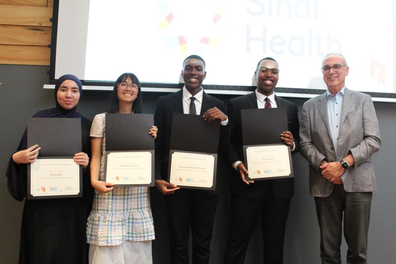 Four youth holding their certificates while standing with a IIODS donor. 