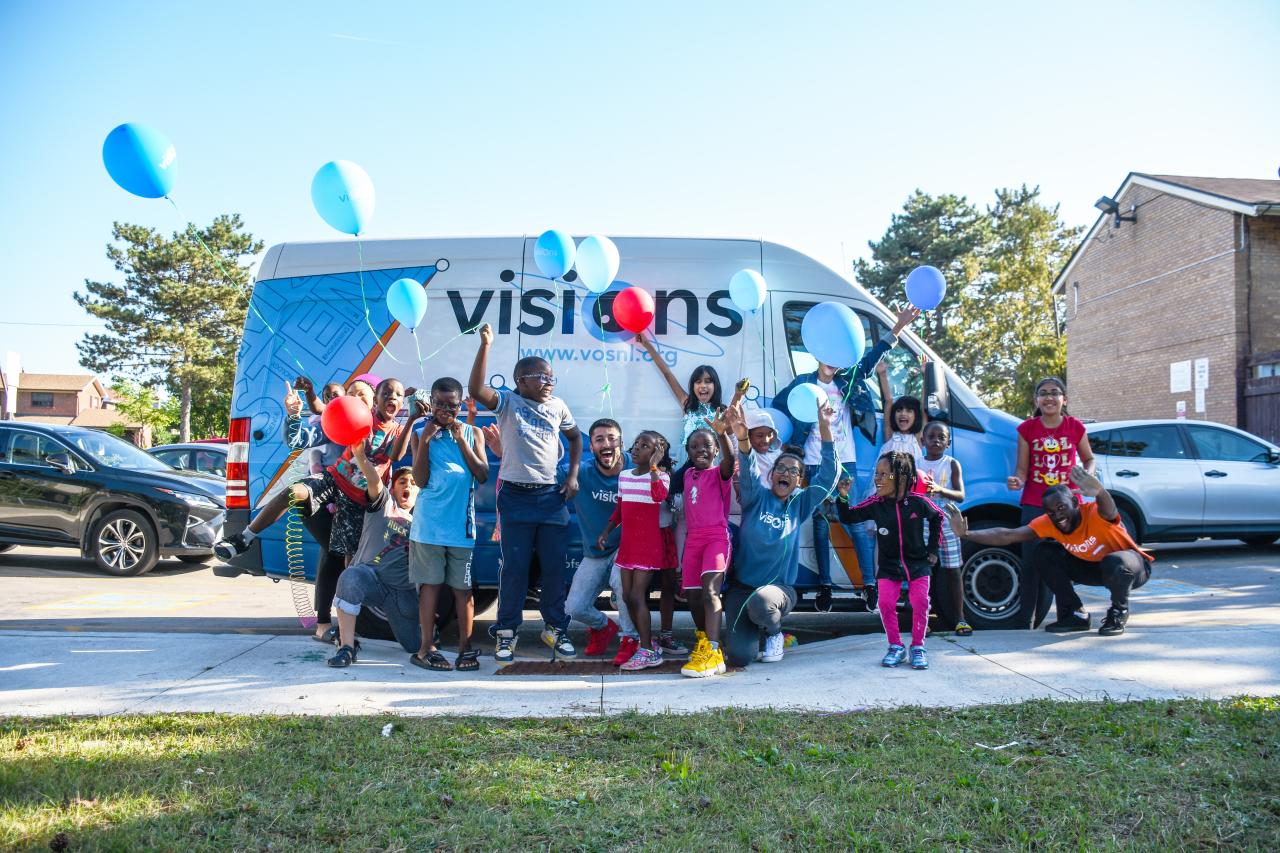 smiling children in front of a van