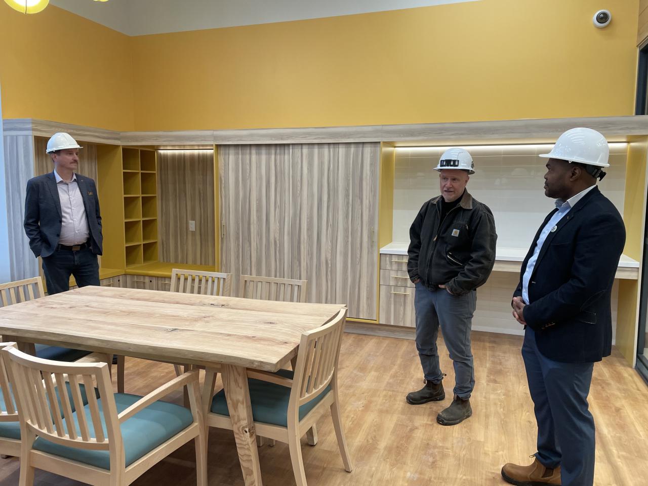 A group of people in hard hats standing in a room