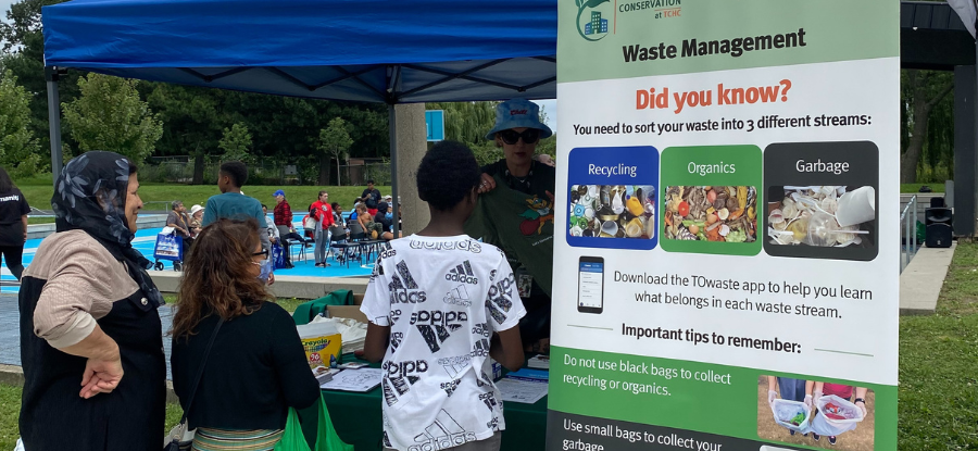 A conservation staff member talking to tenants at a community event outdoors