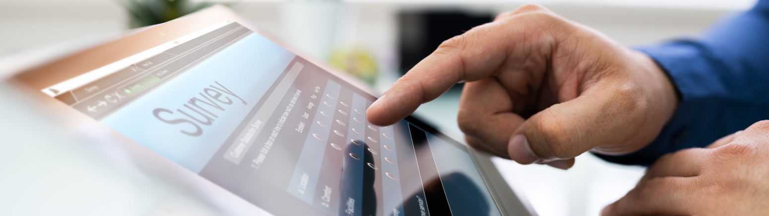 Right hand with index finger extended, hovering over tablet that has the word survey on the screen.