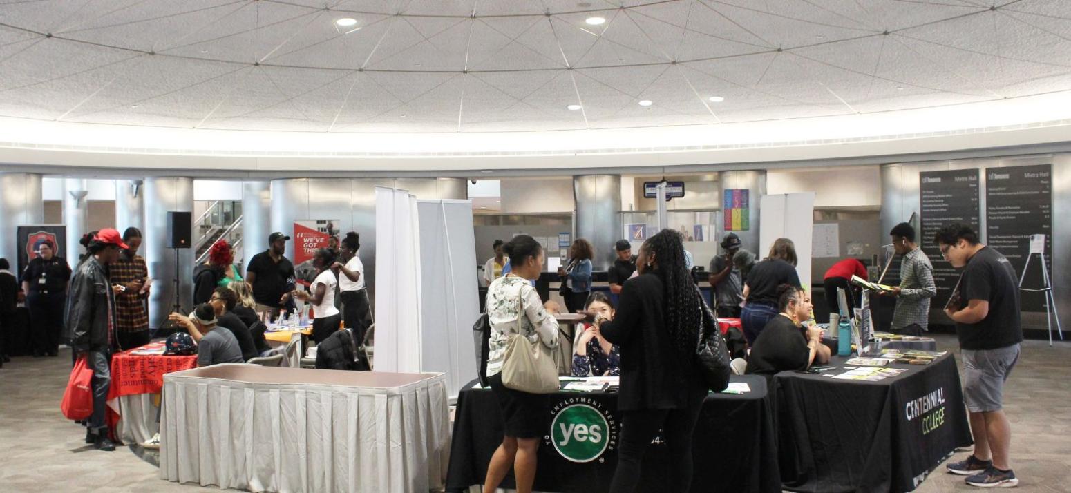 People speaking to representatives at tables.