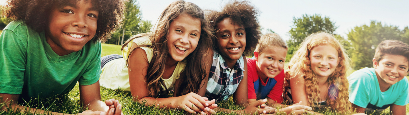 Children laying in a park with arms crossed 