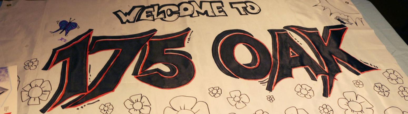 A paper banner with the words "Welcome to 175 Oak" and illustrations of flowers that people can colour in.