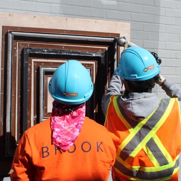 A group of people wearing orange shirts and hard hats