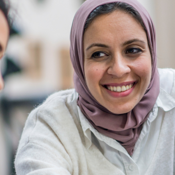 Four people sitting together smiling and talking.